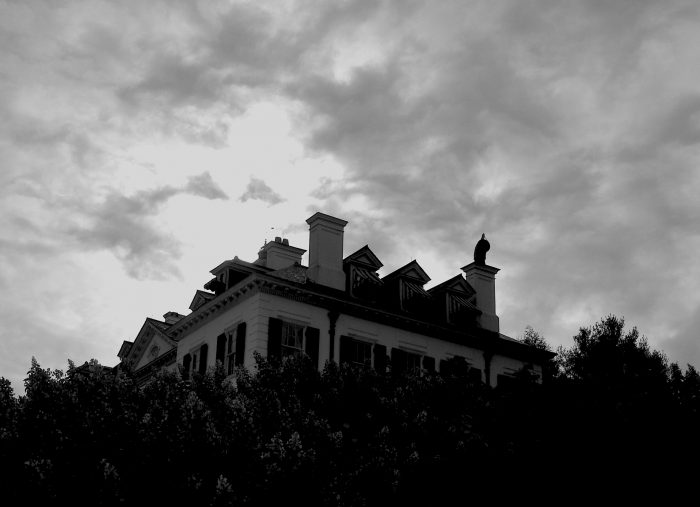 Ominous black and white photo of the roof of The Mount and an overcast sky.