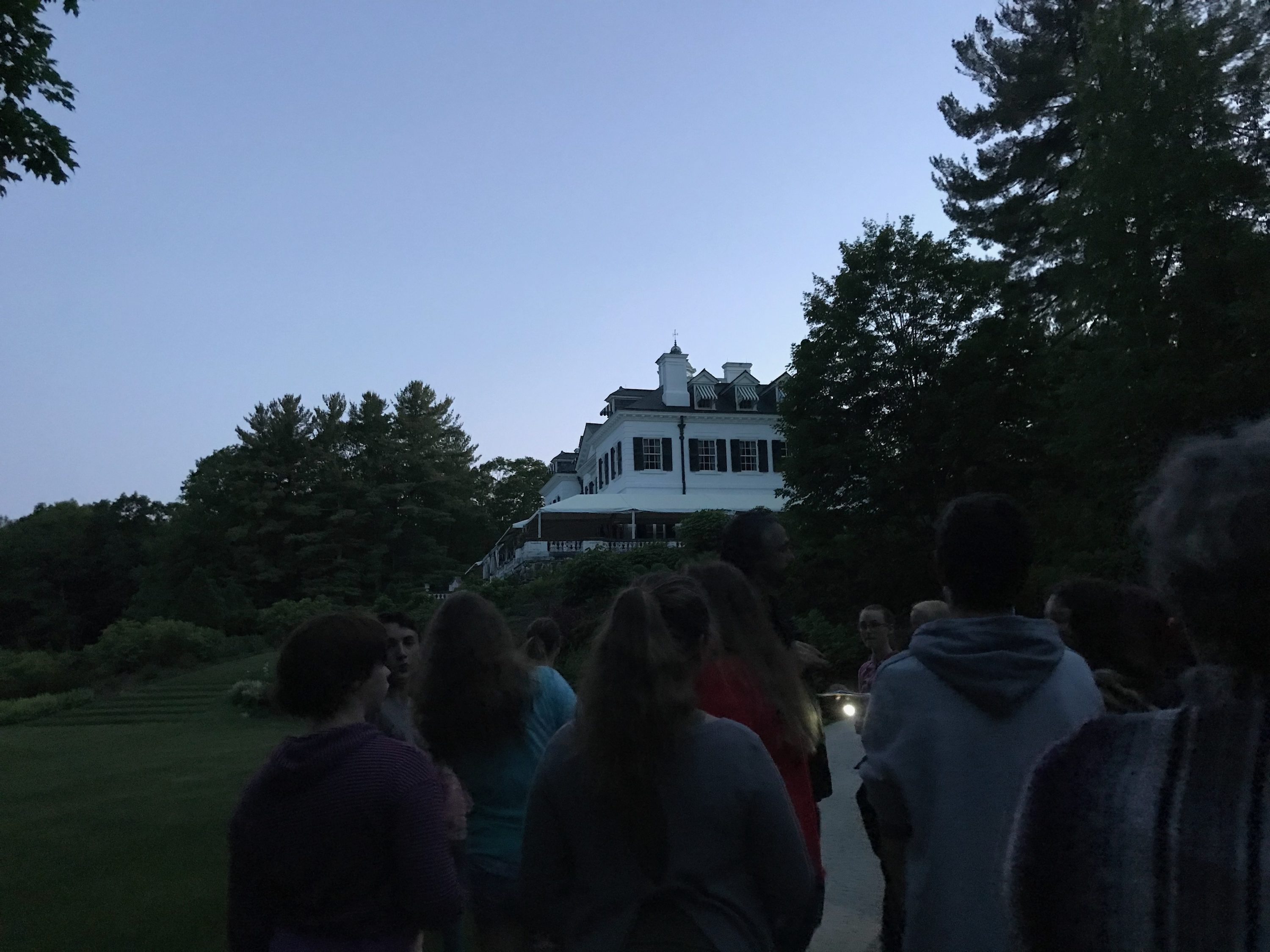 Guests gathered around a tour guide at sunset.